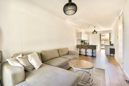 A stylish modern interior featuring a cozy living area with a gray sofa, round coffee table, and...