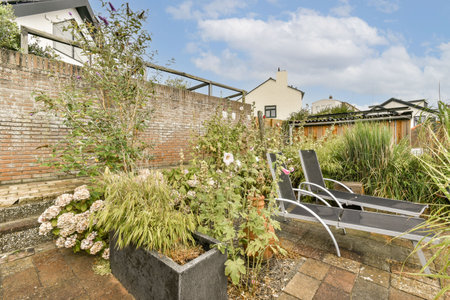 A beautifully arranged garden showcasing vibrant plants and flowers with stylish modern seating,...
