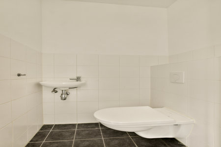 This interior features a modern minimalist bathroom design with clean lines, white tiled walls, and a sleek toilet. The simplicity enhances the spacious feel.の写真素材