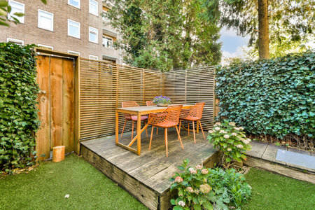 A charming garden dining space featuring a wooden table surrounded by stylish chairs, nestled among...