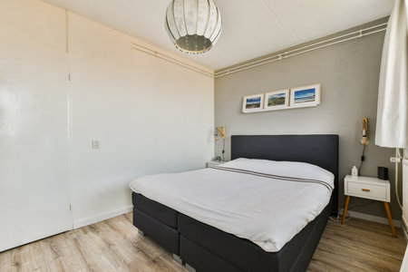 A stylish modern bedroom featuring a simple bed, minimal decor, and natural light. Clean lines and...