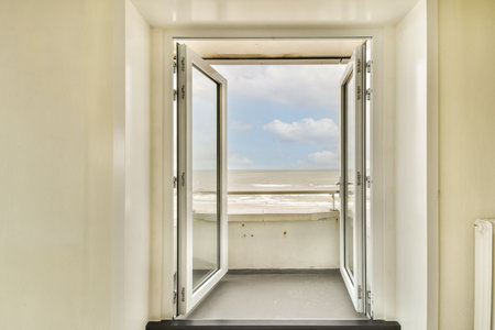 A serene view of the ocean seen through open doors, inviting fresh air and natural light into the room, creating a calm atmosphere.の写真素材