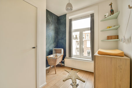 A bright and stylish nursery featuring a crib, minimalistic furniture, and large windows allowing natural light to illuminate the space.の写真素材