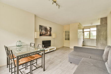 A stylish modern living room featuring a cozy seating area, elegant dining table, and artistic wall decor, combining functionality with aesthetic appeal.の写真素材