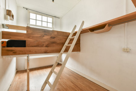 An elegant, modern interior showcasing wooden elements, a ladder, and clean lines. Bright natural light enriches the minimalist design.の写真素材