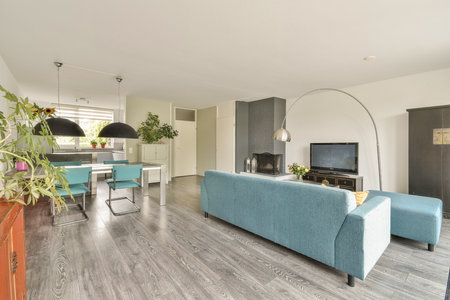 A stylish living room featuring contemporary furniture, green plants, and a sleek television setup, creating an inviting atmosphere for relaxation and socializing.の写真素材