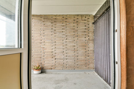 A modern entrance showcasing textured brick walls, a clean floor, and minimal decor, creating a sleek and inviting atmosphere.の写真素材