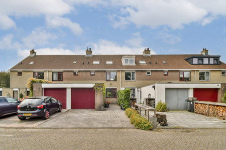 A picturesque view of a residential street featuring modern homes with distinct architecture and vibrant landscaping, creating a welcoming neighborhood atmosphere.の写真素材