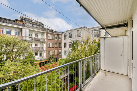 A serene balcony view capturing an urban scene with residential buildings surrounded by greenery. Ideal for exploring city life and architecture.の写真素材