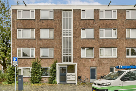 A modern residential structure featuring attractive brickwork, large windows, and well-maintained surroundings including greenery and parking.の写真素材