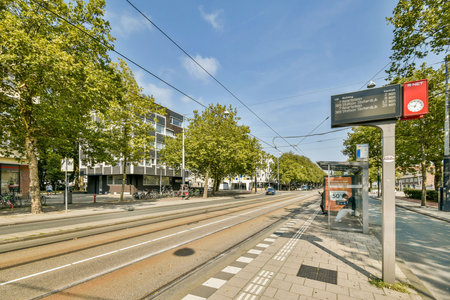 A serene urban setting featuring a tram station surrounded by green trees and clear skies, perfect for commuters and city explorers.の写真素材
