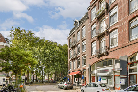 A vibrant urban scene featuring well-maintained buildings, lush greenery, and parked cars, capturing the essence of city life and nature coexisting harmoniously.の写真素材
