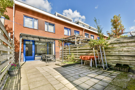 A contemporary urban garden featuring a clear blue sky, elegant patio area with furniture, and neatly arranged plants. Perfect for relaxing or outdoor gatherings.の写真素材