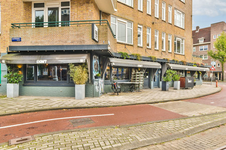 A picturesque urban street showcasing cafes with outdoor seating, surrounded by modern buildings and neatly paved pathways. A lively atmosphere invites visitors.の写真素材