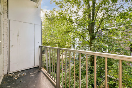 A calming balcony view showcasing vibrant green trees and foliage, inviting relaxation and a connection to nature.の写真素材