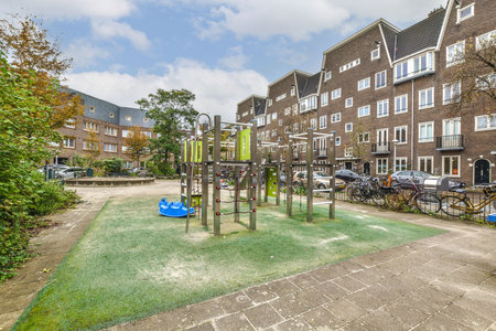 A vibrant playground features various structures amid residential buildings, creating a lively urban environment for children and families.の写真素材