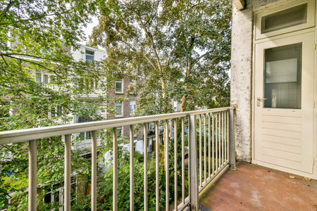 A serene balcony view showcasing lush trees and vegetation, blending natural beauty with urban living. Perfect for relaxation and enjoying natures tranquility.の写真素材