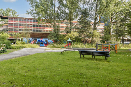 A serene park featuring lush greenery, pathways, and modern architecture in the background, perfect for relaxation and leisure activities.の写真素材