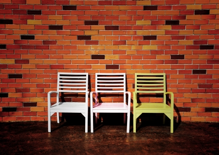 three chairs with beautiful red brick wall backgroundの写真素材