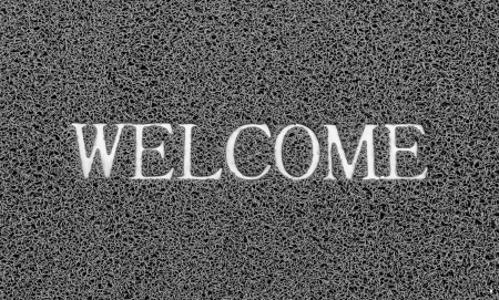 Welcome title on the gray plastic doormat for texture background.の写真素材