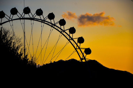 Silhouette of a ferris wheel at sunset.の写真素材