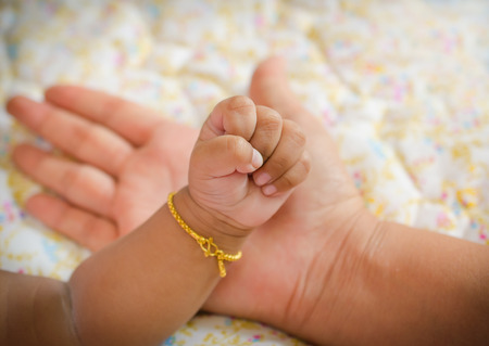 New born baby hand in mom's palm.の写真素材