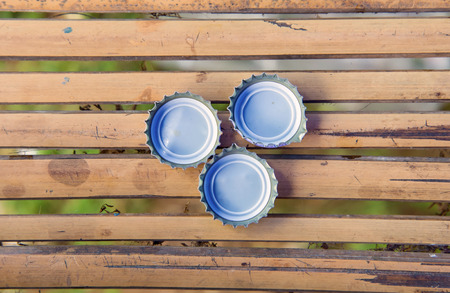 three bottle cap on bamboo
