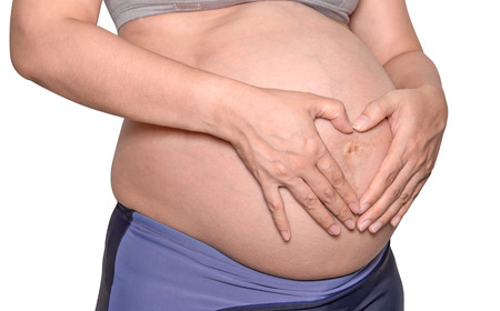 Pregnant woman with hands isolate on white background.の写真素材