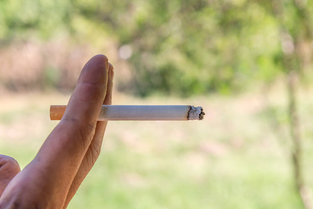 Smoking cigarette with hand closeup in outdoor.の写真素材