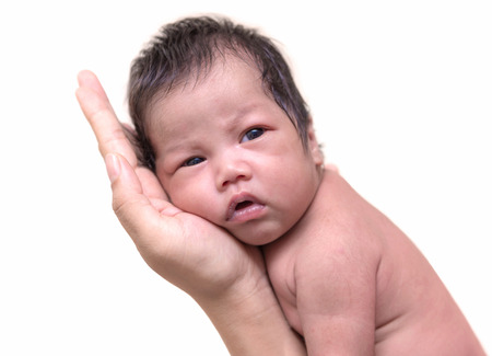 Newborn baby sleep on the hand of mother.の写真素材