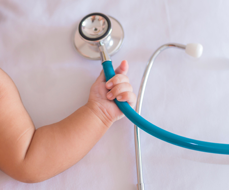 medical instruments stethoscope in hand of newborn baby girl.の写真素材