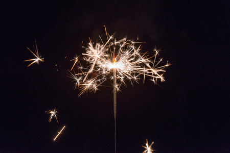 hand holding a sparkler fire on black background.の写真素材
