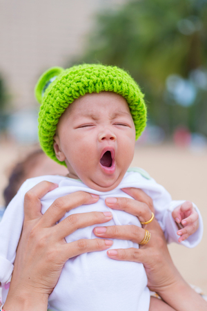 Closeup of face of yawning lying baby.の写真素材