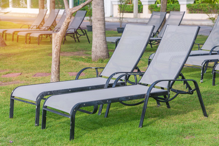 Empty sunbeds on park at tropical beach.