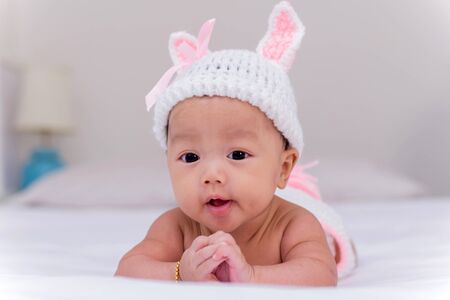 Portrait of cute newborn baby girl on the bedの写真素材