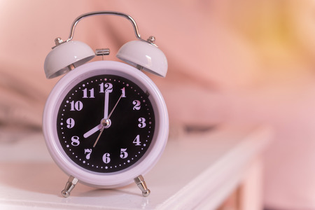 alarm clock on the bed in bedroom, retro style.の写真素材