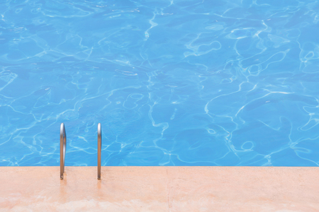 blue swimming pool at hotel with stair.