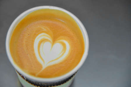 Top view of a paper cup of Latte art coffee.