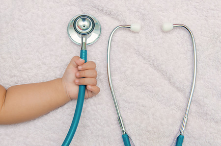 medical instruments stethoscope in hand of baby girl.の写真素材