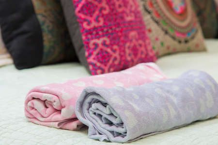 colorful of towel roll on the bed.