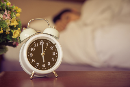 alarm clock on the bed in bedroom.の写真素材