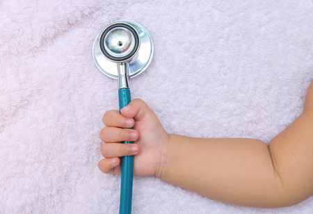 medical instruments stethoscope in hand of newborn baby girl.の写真素材