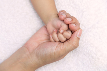 New born baby hand in mom palm.の写真素材