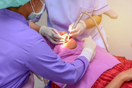 dentist cleaning the teeth patient with ultrasonic toolの写真素材