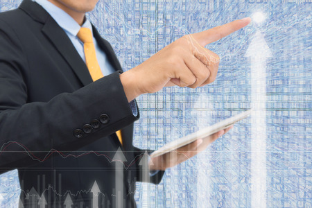 business man Trading concept using the tablet with financial graph on cityscape background, Double exposure style.の写真素材