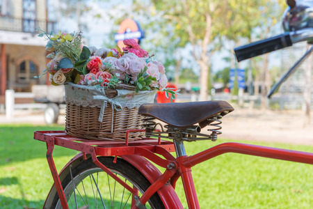 vintage bicycle equipped with basket of flowers in the garden.の写真素材