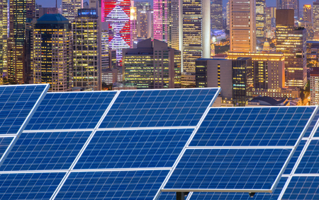 Power plant using renewable solar energy with city building background.
