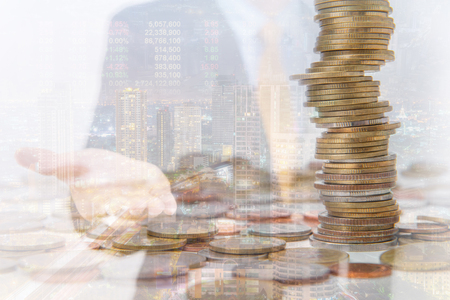 Double exposure of city and coins for finance and business concept.の写真素材