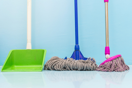 cleaning floor with wet mop and dustpan in room.の写真素材