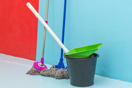 cleaning floor with wet mop and dustpan in room.の写真素材